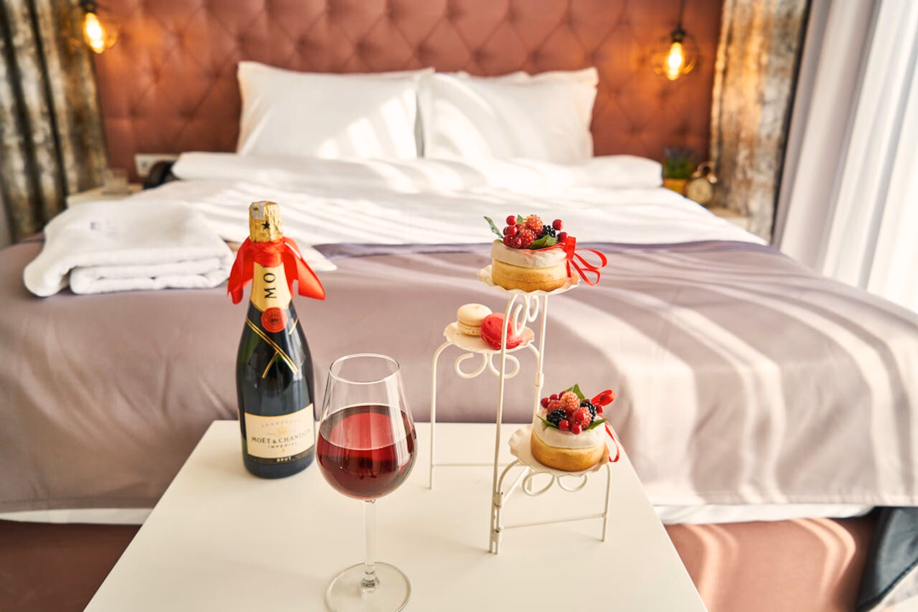 Eine Flasche Moet und süßes Gebäck in einem Hotelzimmer drapiert