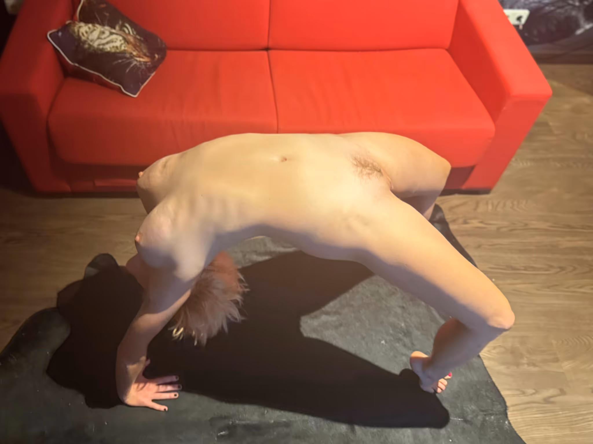 Dieses Bild zeigt Olivia Leipzig Escort in einer spektakulären Rückbeuge, vollkommen nackt, stark und biegsam. Die sinnliche Pose vor dem roten Sofa unterstreicht ihre erotische Ausstrahlung und beeindruckende Körperbeherrschung. Eine Escort Lady, die Ästhetik, Leidenschaft und Lust in sich vereint.