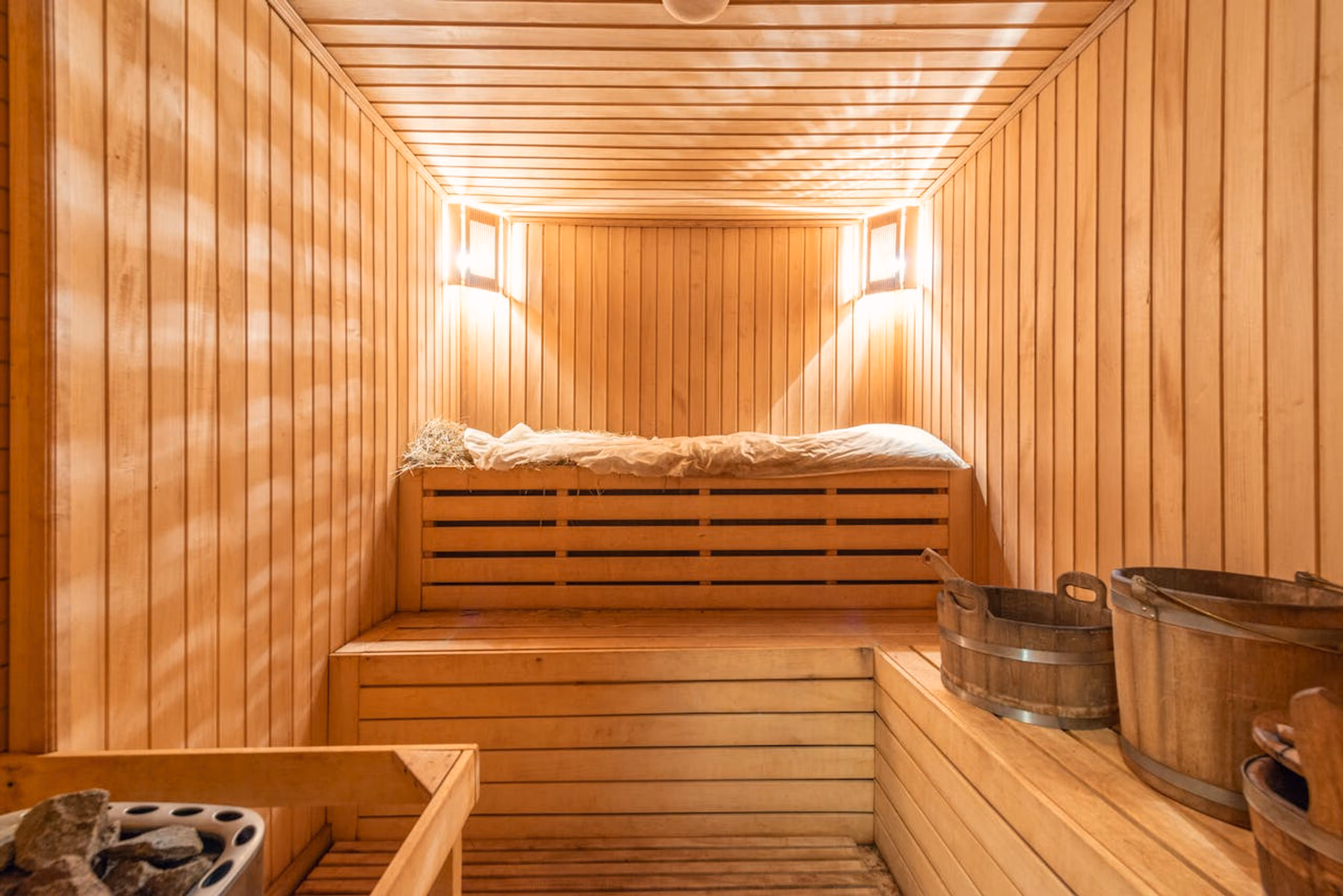 zu sehen ist eine Sauna von innen mit Möglichkeiten für Aufgüsse