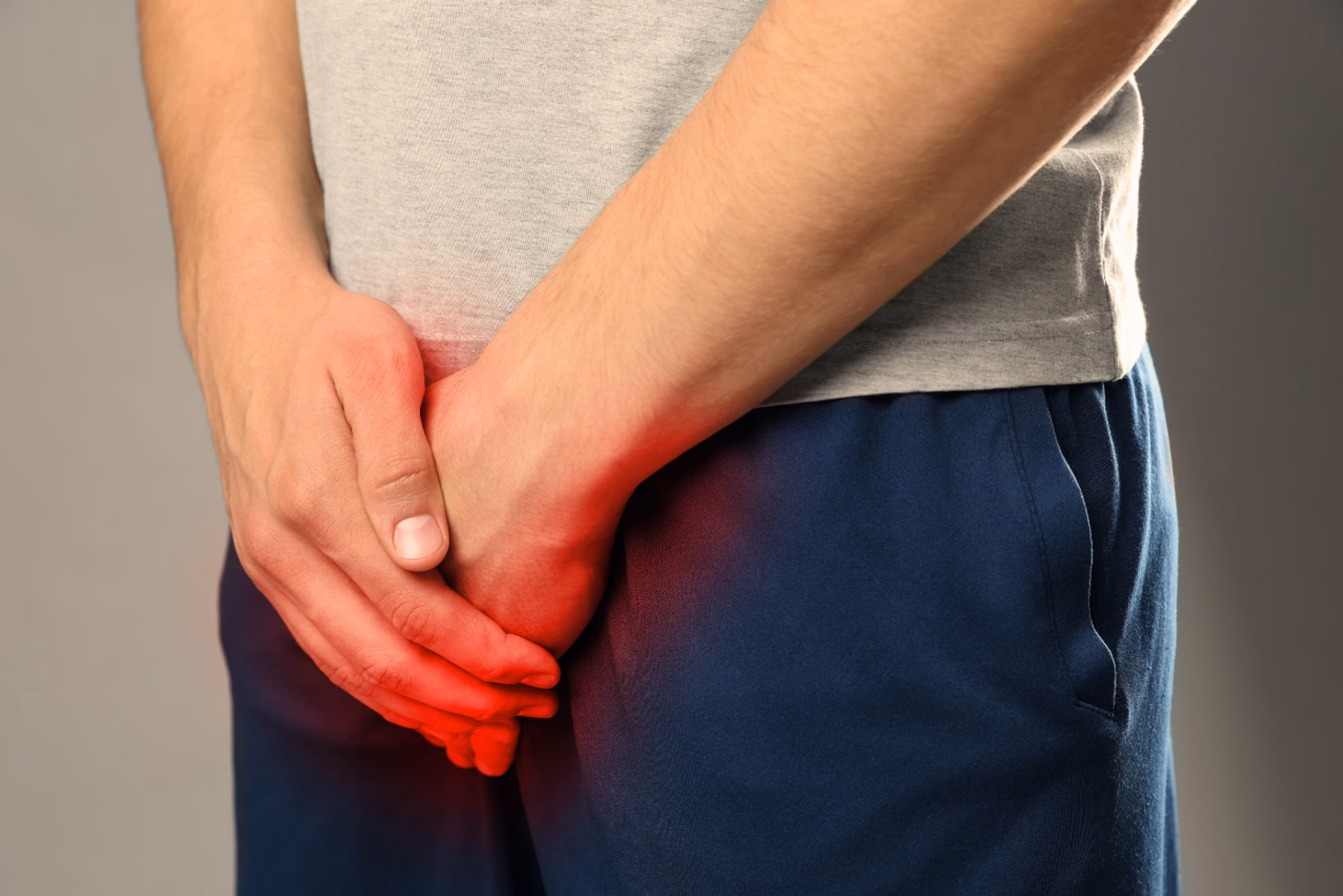 Ein Mann, fotografiert in der Mitte seines Köpers, in Shorts und T-Shirt gekleidet 