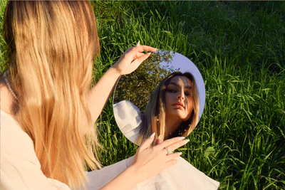 eine junge Frau, die sich im Spiegel ansieht