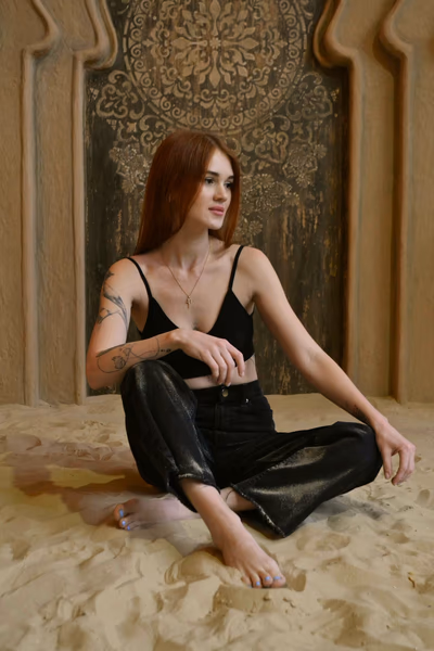 Eine Frau mit roten Haaren, sehr weiblich, besonnen auf sich